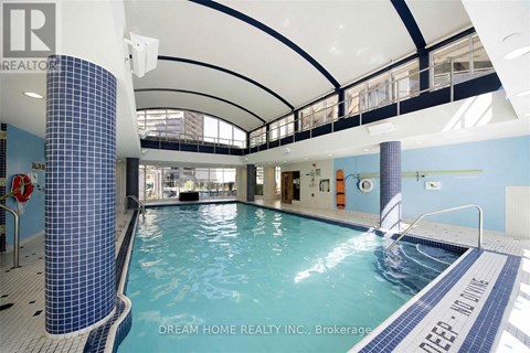 A swimming pool inside a building with a blue tiled column.