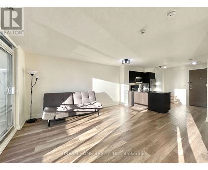 A modern living room with a grey sofa and wooden flooring.