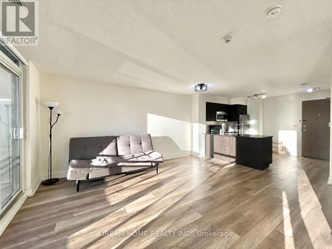 A modern living room with a grey sofa and wooden flooring.