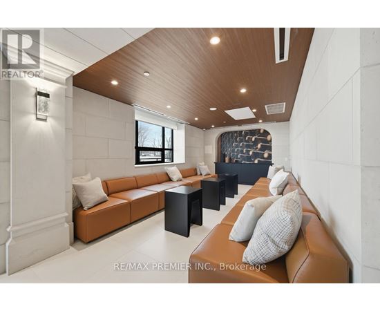 A modern living room with a brown leather couch and a wooden ceiling.