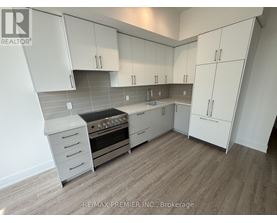 A kitchen with white cabinets and a stove top oven.