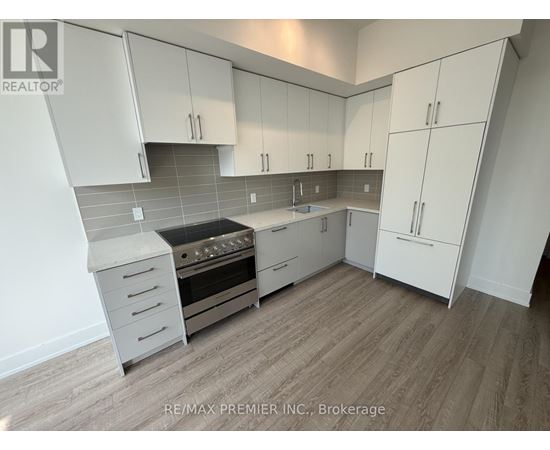 A kitchen with white cabinets and a stove top oven.