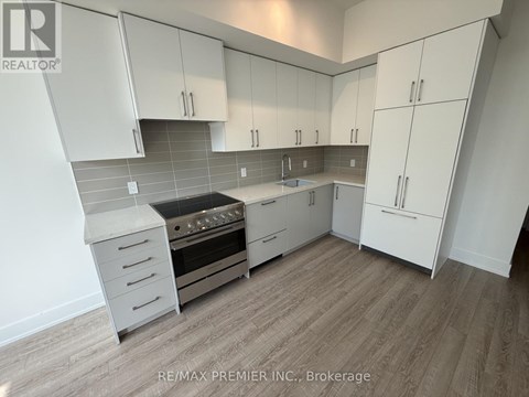 A kitchen with white cabinets and a stove top oven.