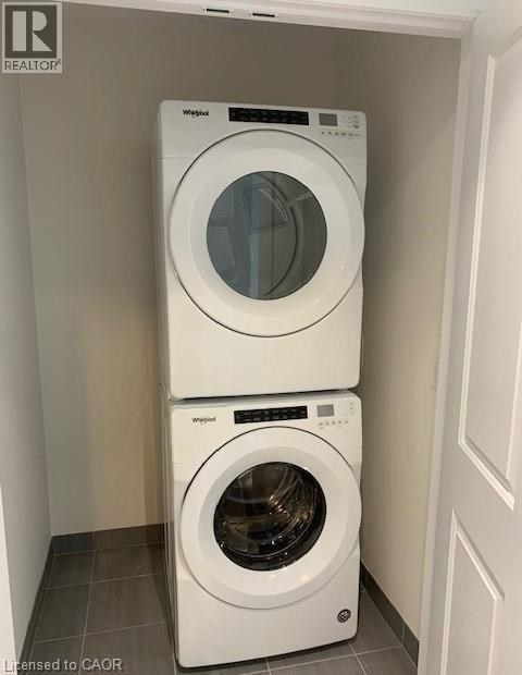 Two white front load washing machines stacked on top of each other in a laundry room.