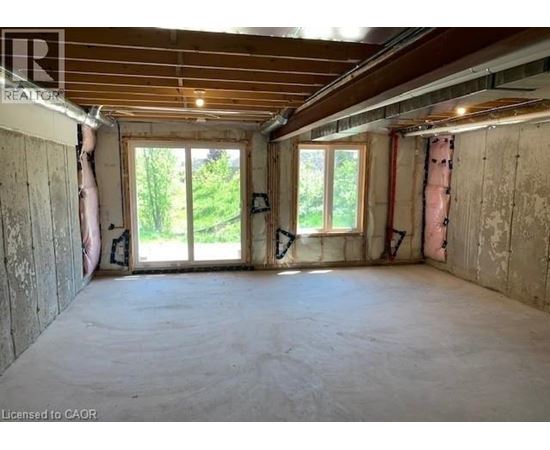 A room under construction with exposed wooden beams and unfinished walls.
