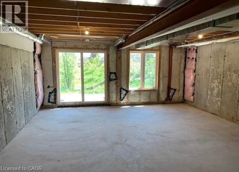 A room under construction with exposed wooden beams and unfinished walls.