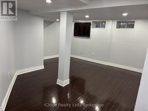 A large empty room with wooden floors and white walls.