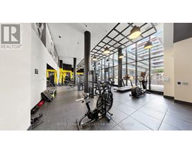 A gym with a variety of equipment including treadmills, stationary bikes, and weights.