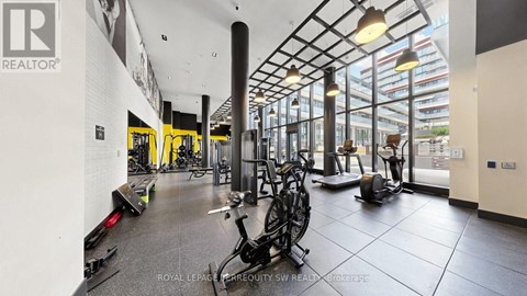 A gym with a variety of equipment including treadmills, stationary bikes, and weights.