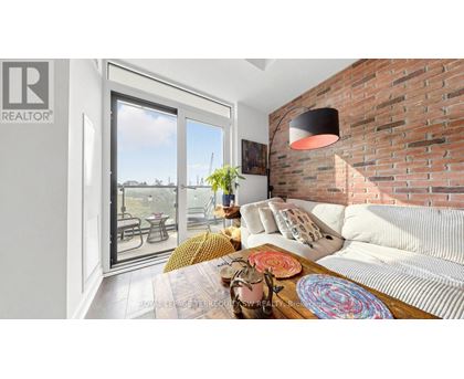 A living room with a white couch and a brick wall.