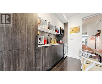 A kitchen with a wooden cabinet and a white counter.