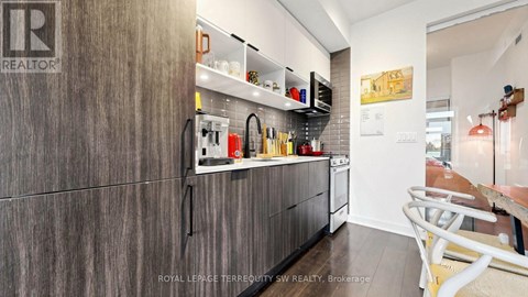 A kitchen with a wooden cabinet and a white counter.