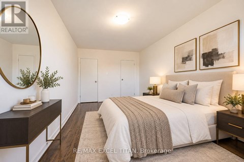 A bedroom with a large bed, a mirror, and two framed pictures on the wall.