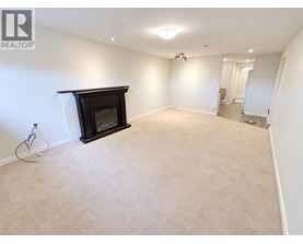 A living room with a fireplace and carpeted floor.