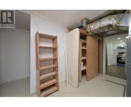 A room with a ladder and a doorway leading to another room.