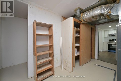 A room with a ladder and a doorway leading to another room.
