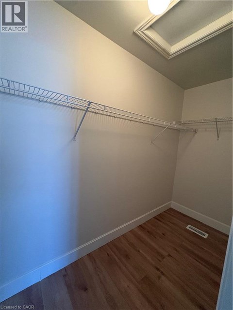 Empty room with a white wall and a wooden floor.