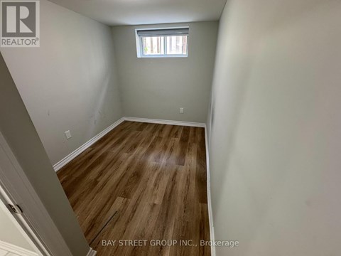 A room with wooden flooring and a window.