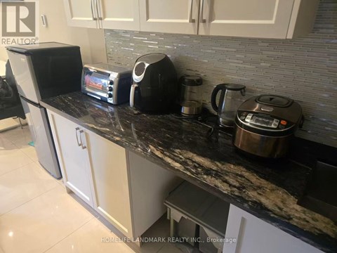 A black and silver toaster and coffee maker sit on a kitchen counter.