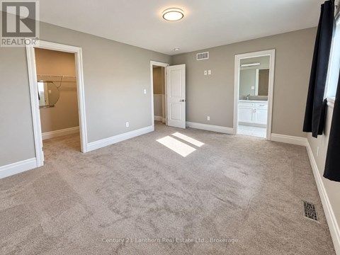 A spacious room with a carpeted floor and white walls.