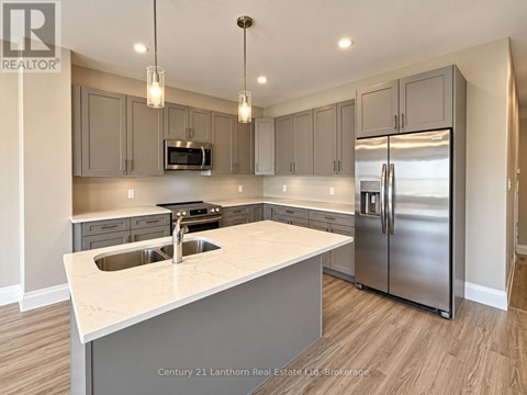 A modern kitchen with a stainless steel refrigerator and a white countertop.