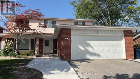 A house with a white garage door and a red brick wall.