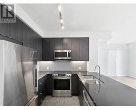 A modern kitchen with dark wood cabinets and stainless steel appliances.