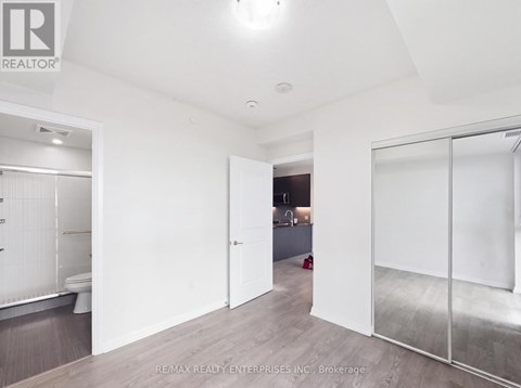 A white room with a glass door leading to another room.