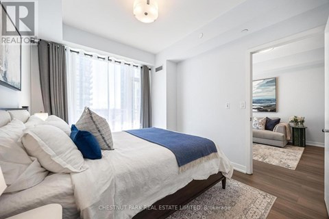 A bedroom with a large bed and a view of the outdoors through the window.