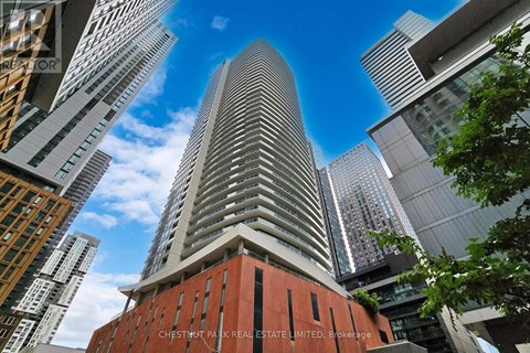 A tall building with a red base and a curved top stands out against the skyline.