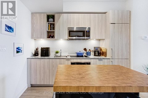 A modern kitchen with wooden cabinets and a wooden table.