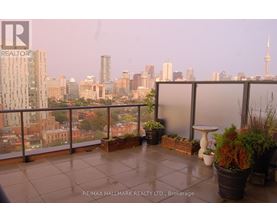A balcony with potted plants and a table overlooking a city skyline.