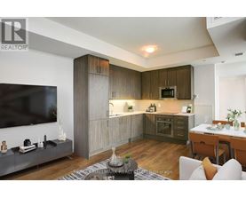 A modern kitchen with wooden cabinets and a TV mounted on the wall.
