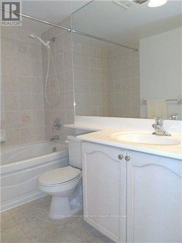A white bathroom with a toilet, sink, and bathtub.