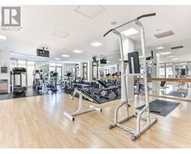 A gym with a variety of equipment including treadmills, weights, and exercise machines.