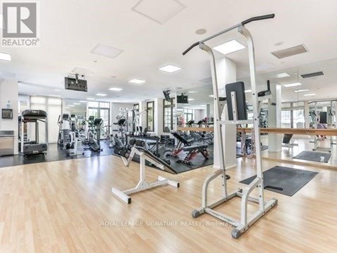 A gym with a variety of equipment including treadmills, weights, and exercise machines.