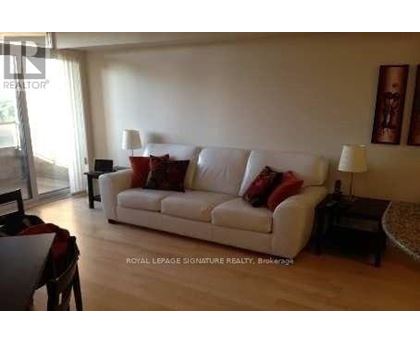 A living room with a white couch and a coffee table.