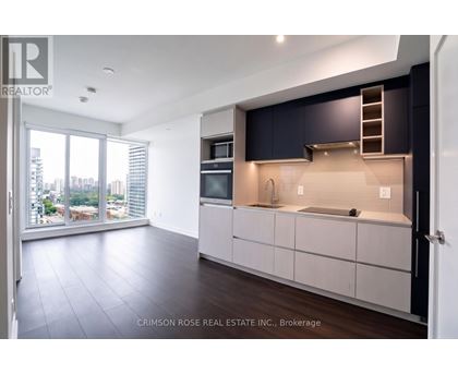 A modern kitchen with dark blue cabinets and a view of the city.