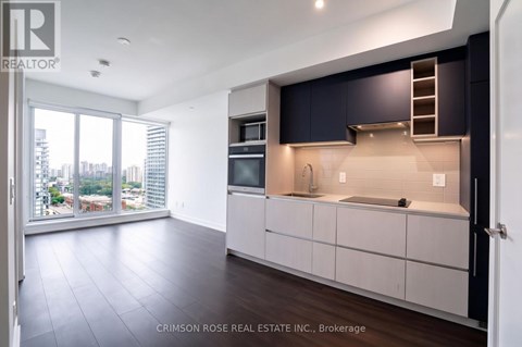 A modern kitchen with dark blue cabinets and a view of the city.