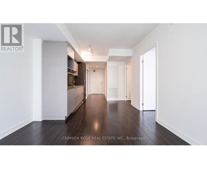 A long hallway with white walls and wood floors.