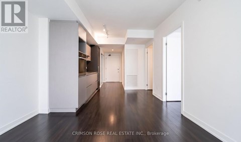 A long hallway with white walls and wood floors.