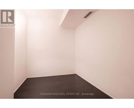 A white room with a black floor and a logo on the wall.