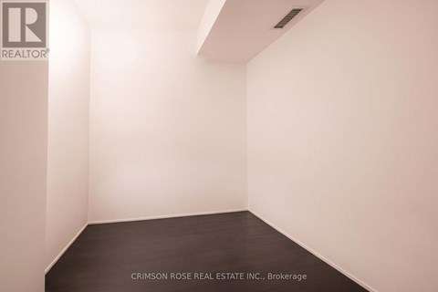 A white room with a black floor and a logo on the wall.