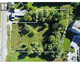 An aerial view of a property with a large green area and a building on the right.