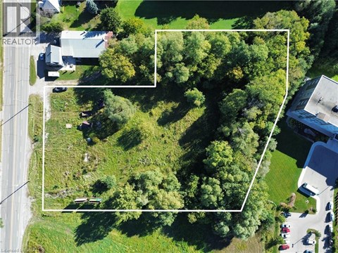 An aerial view of a property with a large green area and a building on the right.