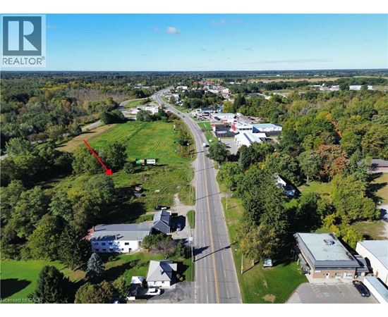 An aerial view of a town with a red arrow pointing to a specific location.