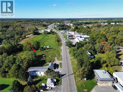 An aerial view of a town with a red arrow pointing to a specific location.