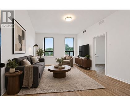 A living room with a couch, a coffee table, and a flat screen TV.