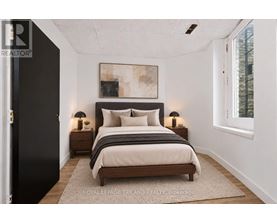 A bedroom with a large bed and two nightstands.