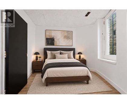 A bedroom with a large bed and two nightstands.